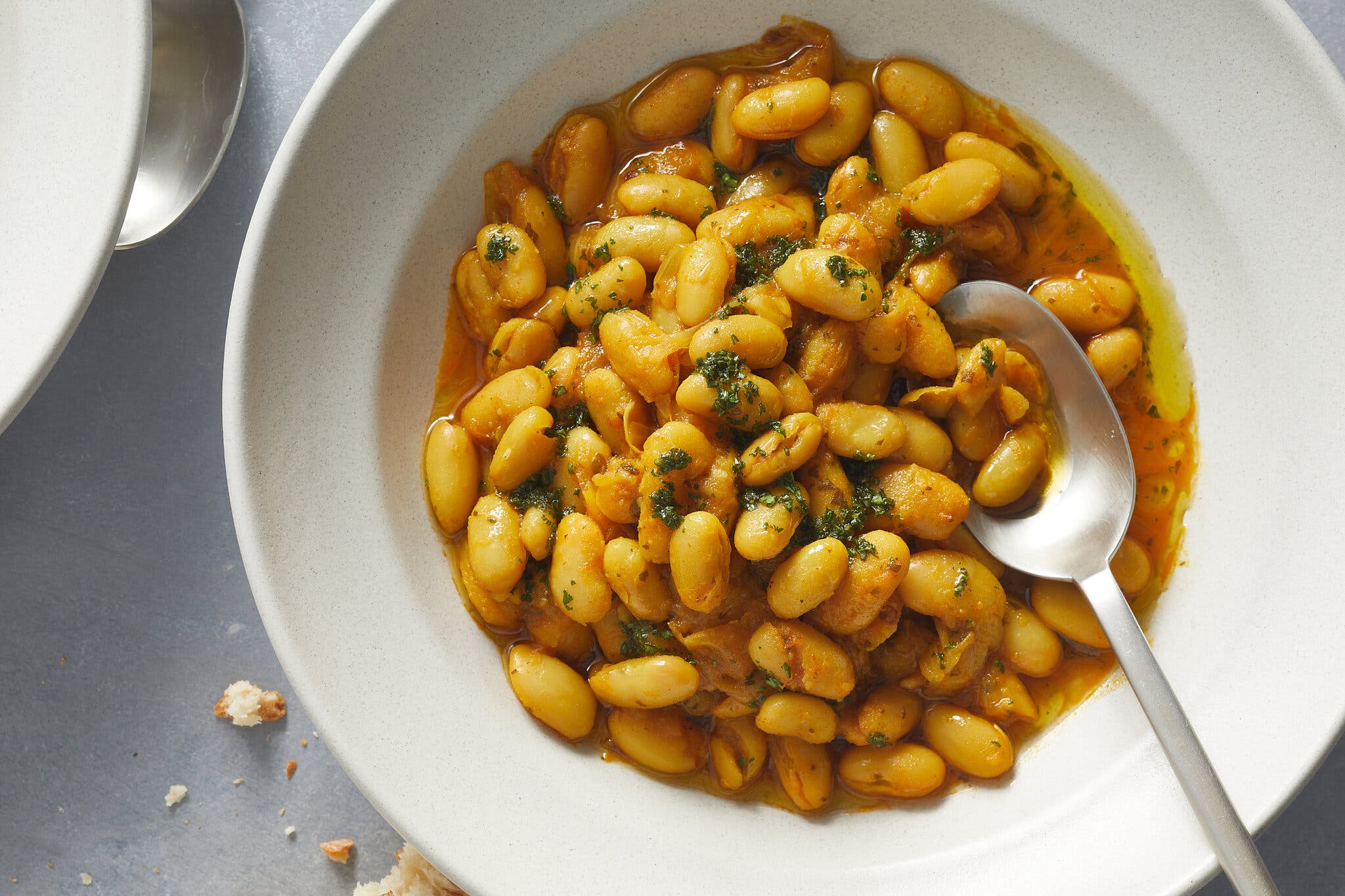 White beans in a golden broth sit in a bowl.