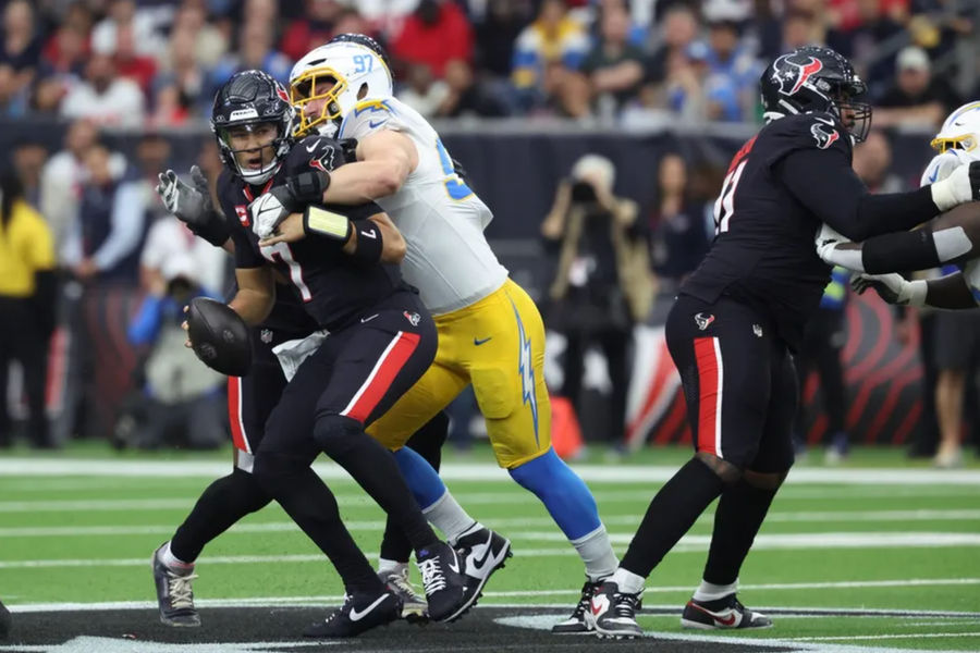 Jan 11, 2025; Houston, Texas, USA; Los Angeles Chargers outside linebacker Joey Bosa (97) sacks Houston Texans quarterback C.J. Stroud (7) during the first quarter in an AFC wild card game at NRG Stadium. Mandatory Credit: Troy Taormina-Imagn Images