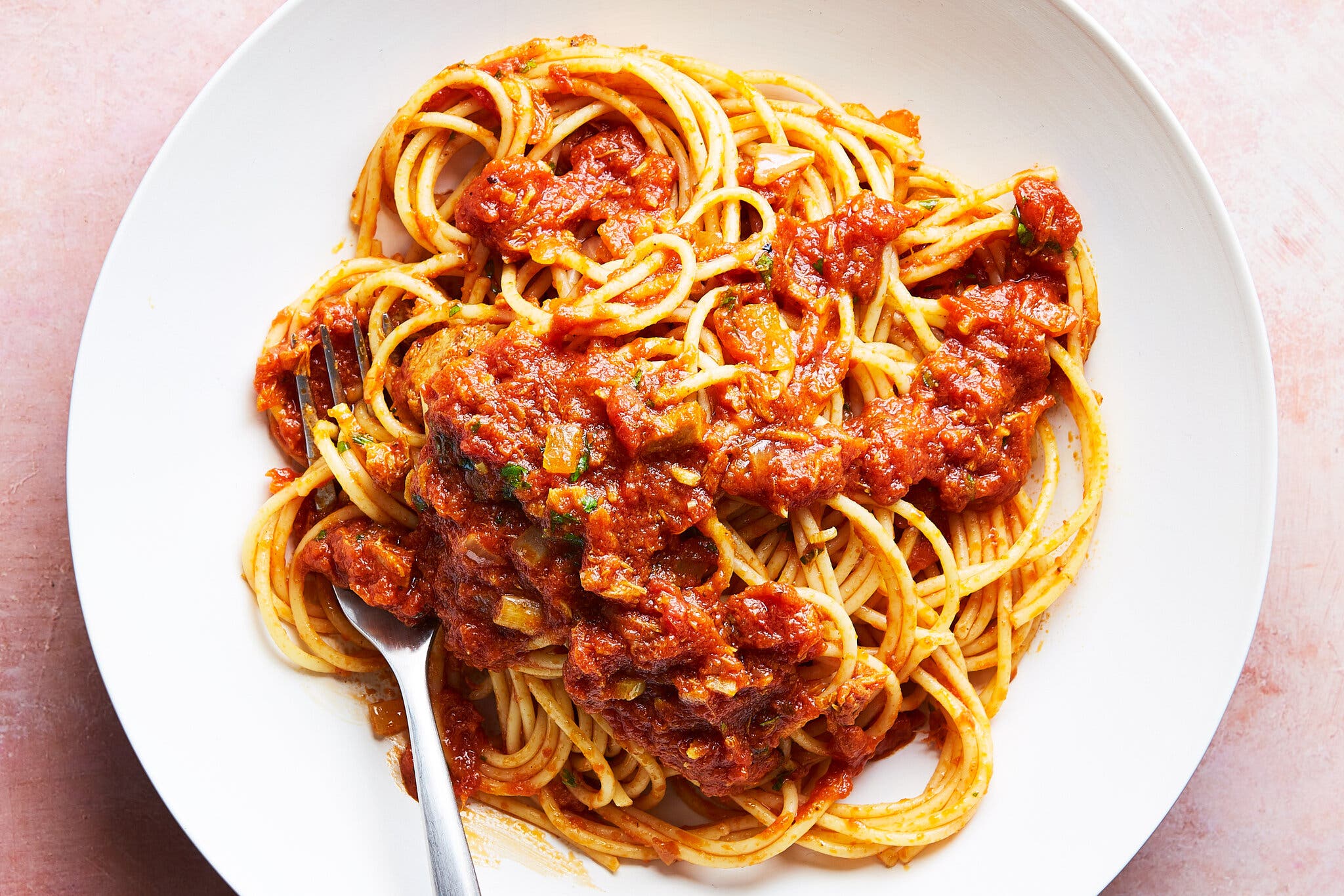 An overhead image of spaghetti on a plate with pasta and tuna.