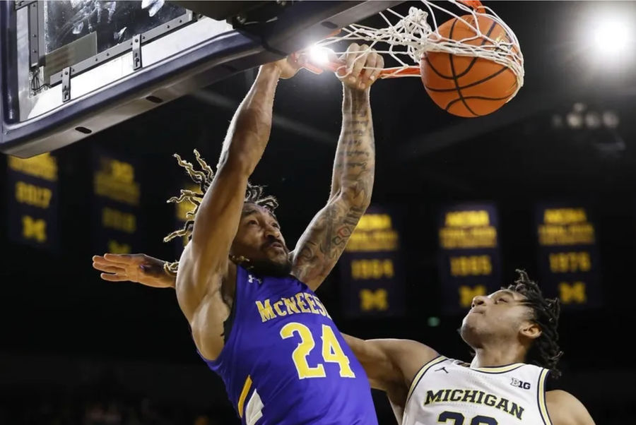 Dec 29, 2023; Ann Arbor, Michigan, USA; McNeese State Cowboys forward Christian Shumate (24) dunks on Michigan Wolverines forward Tarris Reed Jr. (32) in the second half at Crisler Center. credits: Rick Osentoski-USA TODAY Sports