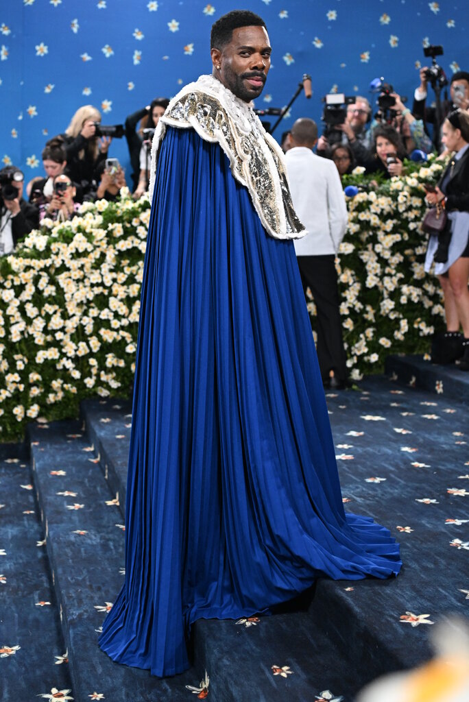 Colman Domingo is wearing a royal blue cape with a silver collar.