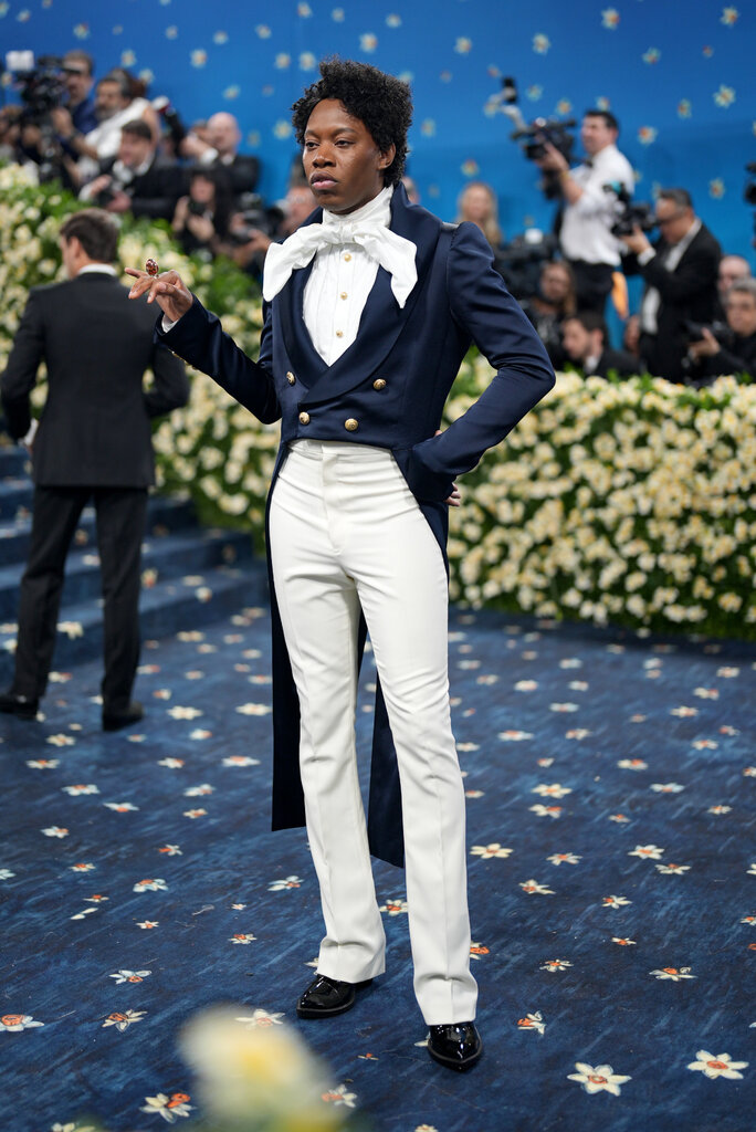a man in a blue top coat and white pants