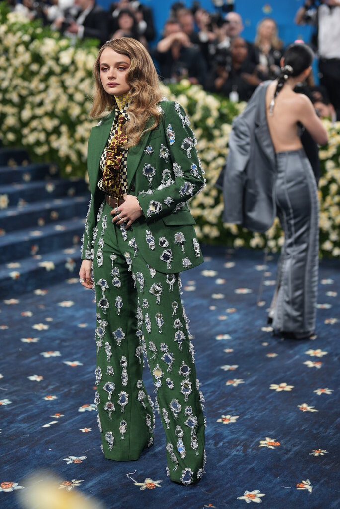 Joey King wearing a green suit, with jeweled and beaded embellishments, and a checkered blouse.