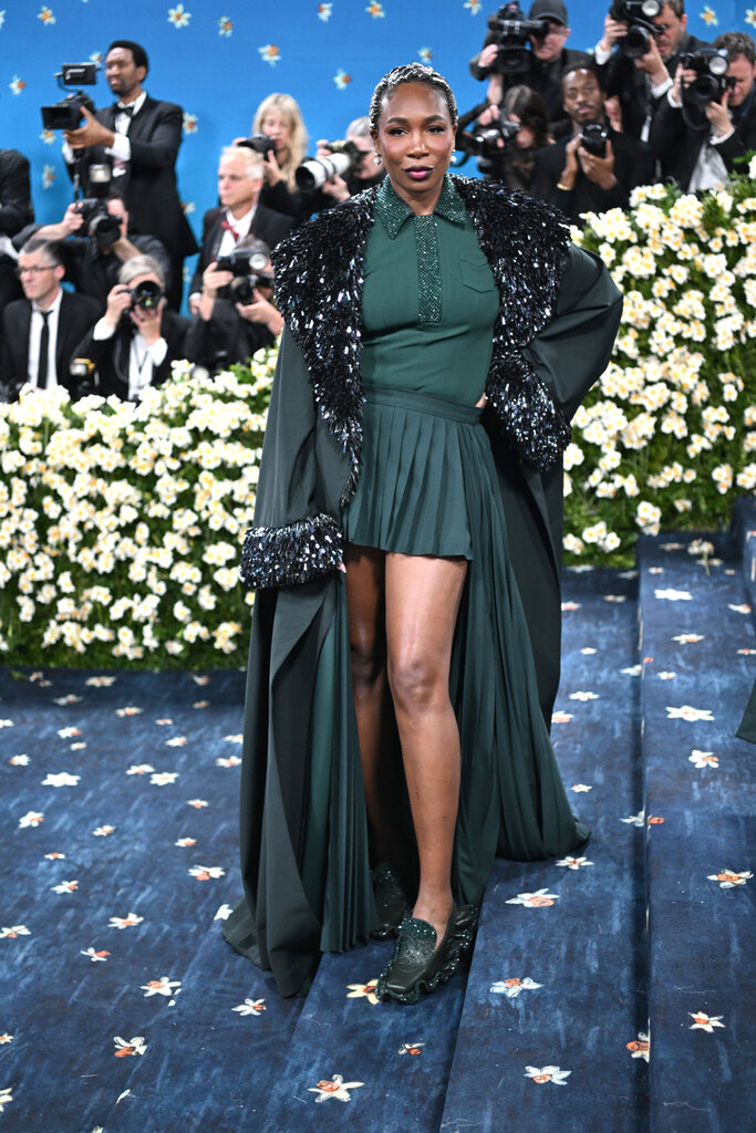 Venus Williams in a green polo shirt, matching tennis skirt and long embroidered jacket