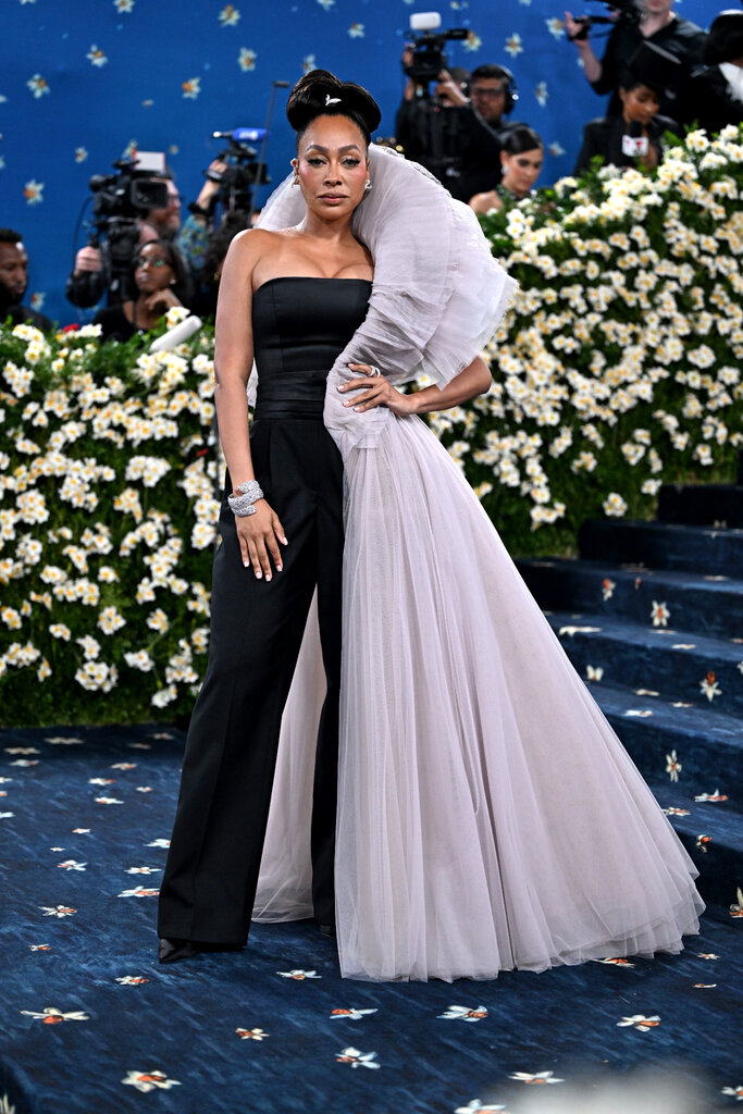 La La Anthony wearing a sleeveless black jumpsuit with a large purple ruffle.