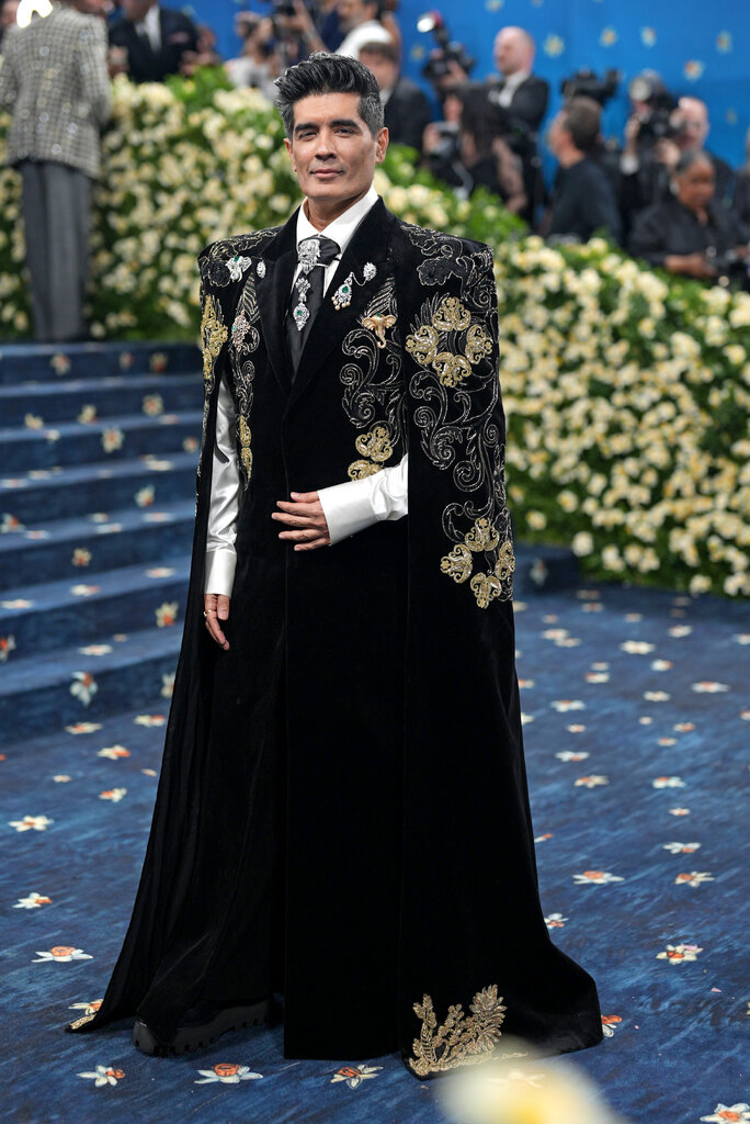 Manish Malhotra wearing a floor-length velvet cape with embroidered detailing.