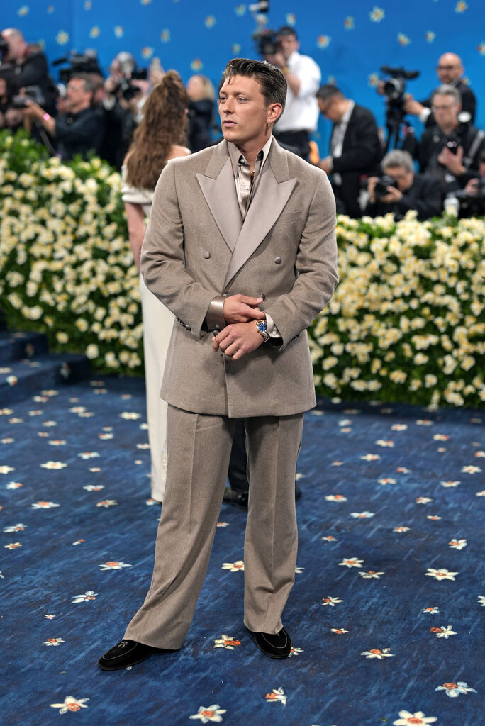 Tom Francis is wearing a beige suit.