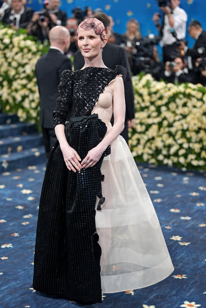 Lauren Amos wearing a black sequined gown, with an exposed corset and sheer skirt on one side.