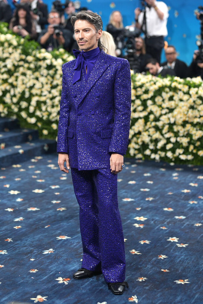 Raul Domingo wearing a purple sequined suit.