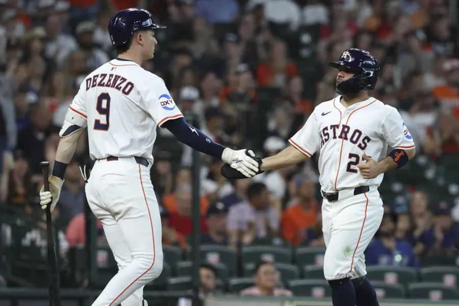 May 10, 2025; Houston, Texas, USA; Houston Astros second baseman Jose Altuve (27) celebrates with left fielder Zach Dezenzo (9) after scoring a run during the first inning against the Cincinnati Reds at Daikin Park. Mandatory Credit: Troy Taormina-Imagn Images