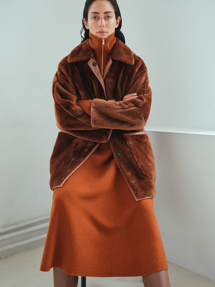 A rich alpaca-blend coat in autumnal tones showcases Max Mara Atelier’s mastery of texture and modern refinement.