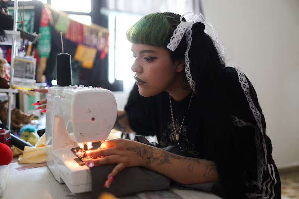 Mexican designer Italia Segovia, 26—known as Kumiko—works on a second-hand blazer for her brand Chicanjuku, blending Chicano and Harajuku styles, at home in Nezahualcóyotl, Mexico, on May 21, 2025.