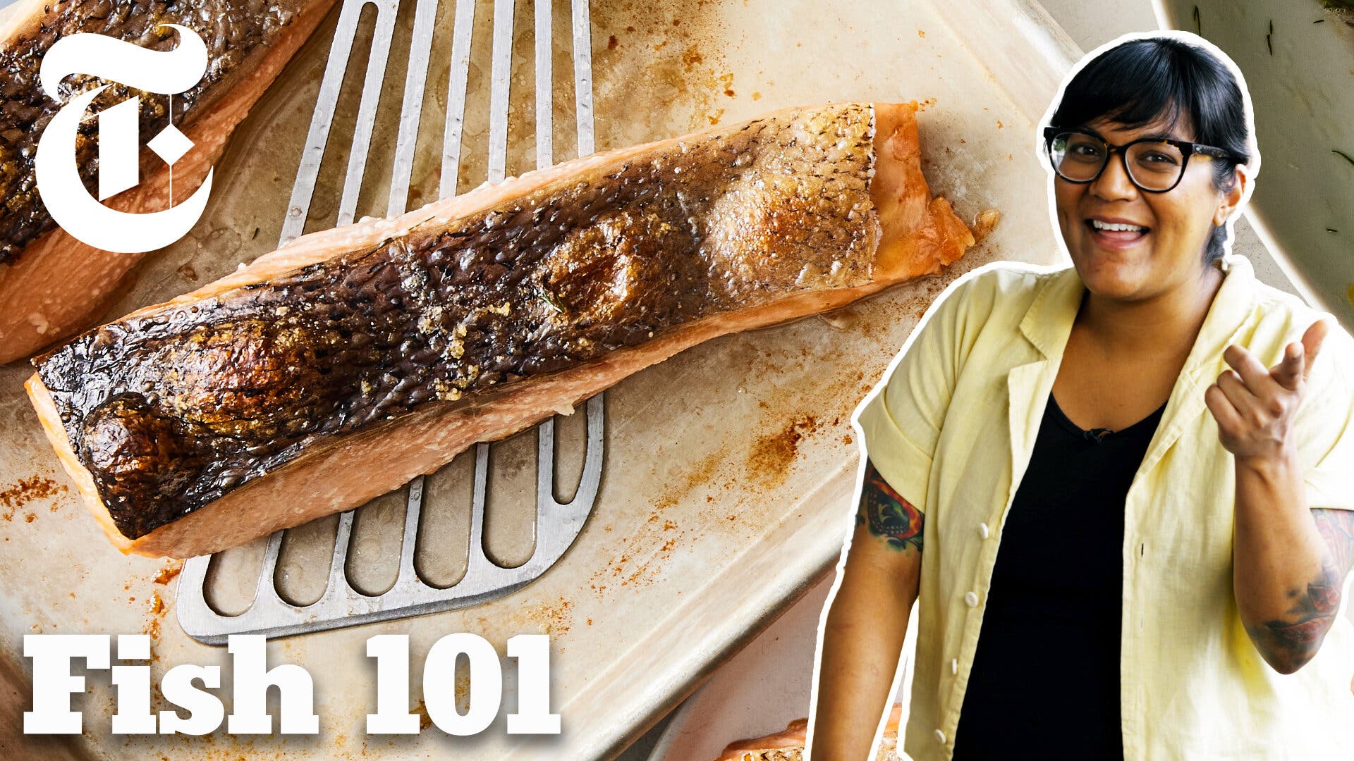 A woman in glasses stands in front of a fillet of salmon on a sheet pan.