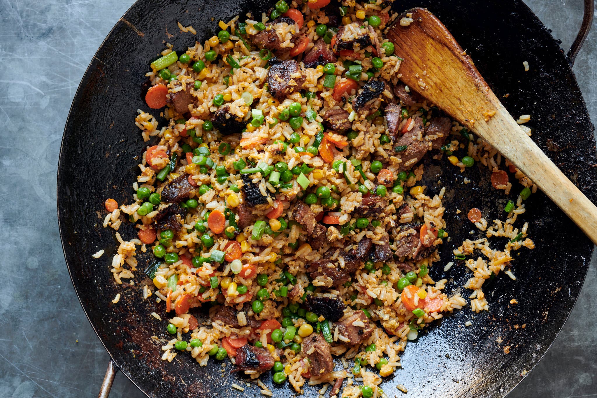An overhead image of rice stir-fried with vegetables and topped with herbs.