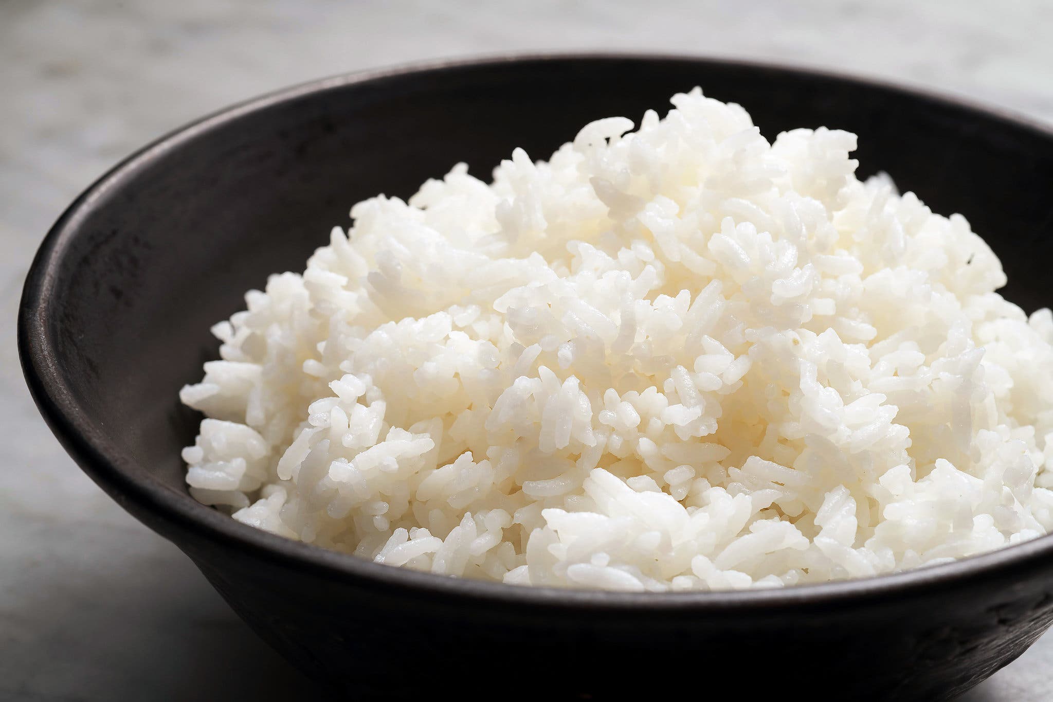 A side image of a black bowl filled with white rice.