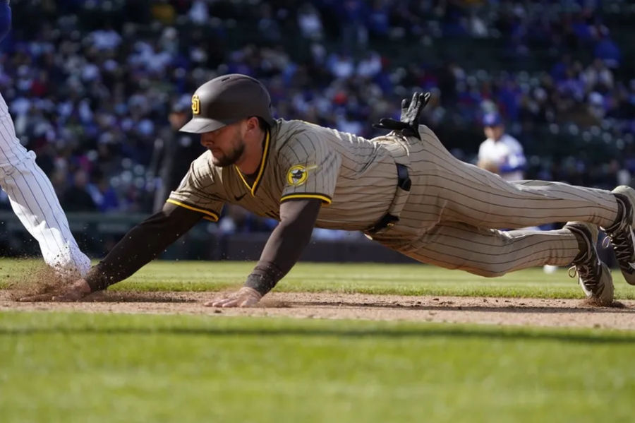 Apr 6, 2025; Chicago, Illinois, USA; San Diego Padres outfielder Jackson Merrill (3) dive into first base against the Chicago Cubs during the eighth inning at Wrigley Field. Mandatory Credit: David Banks-Imagn Images