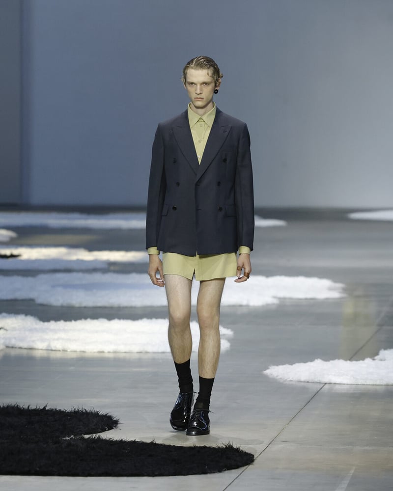 Prada’s cousin energy: sharp tailoring meets leggy rebellion.