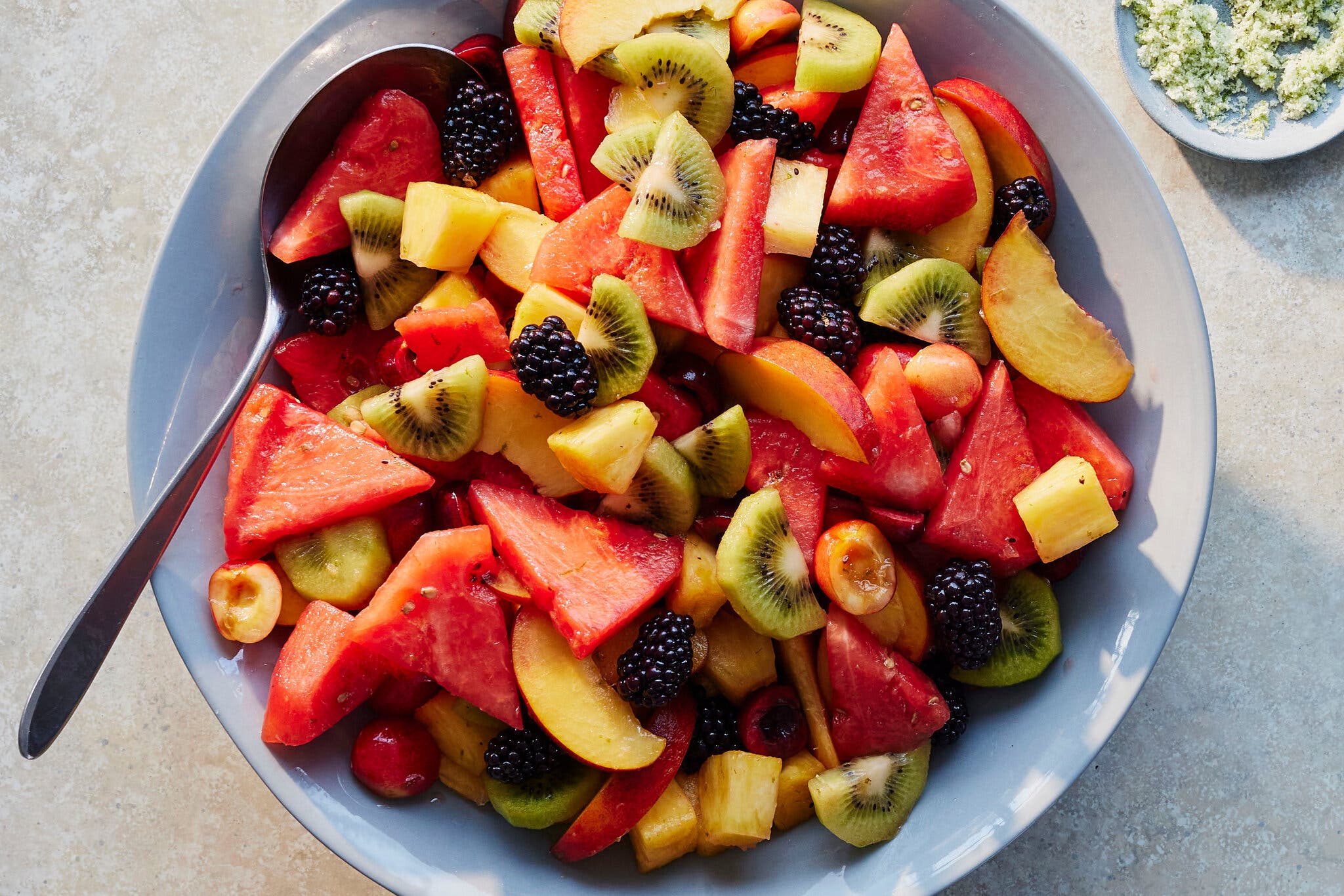 An overhead image of fruit cut into pieces on a large platter.