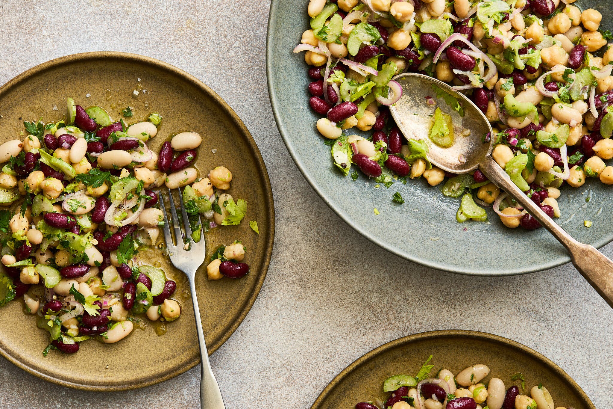 An overhead image of several plates topped with bean salad.