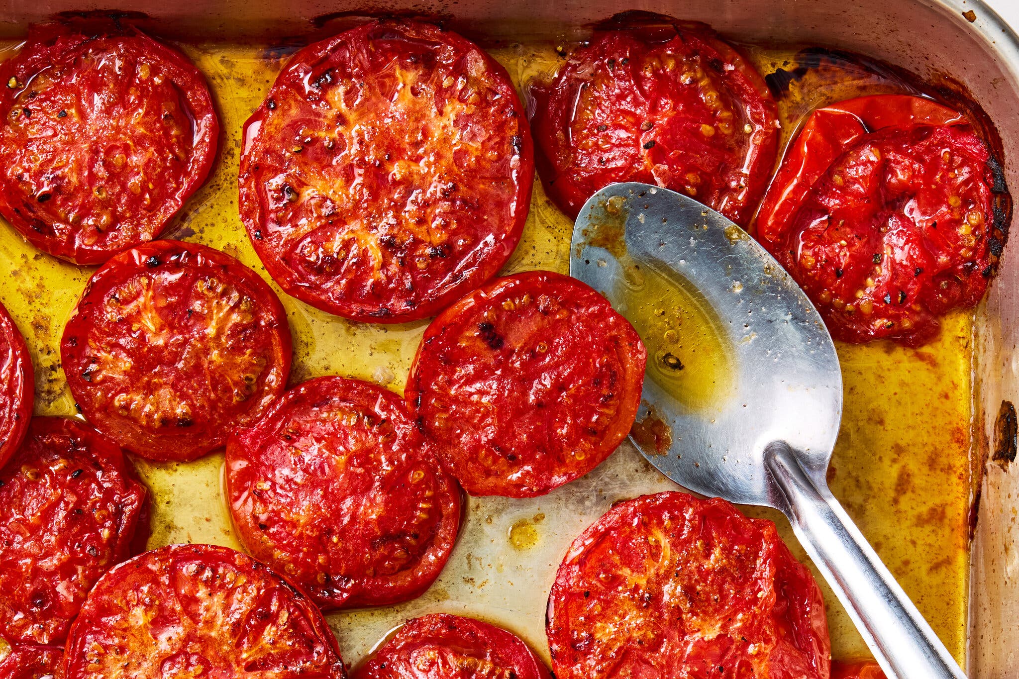 An overhead image of tomatoes cooked down in oil.