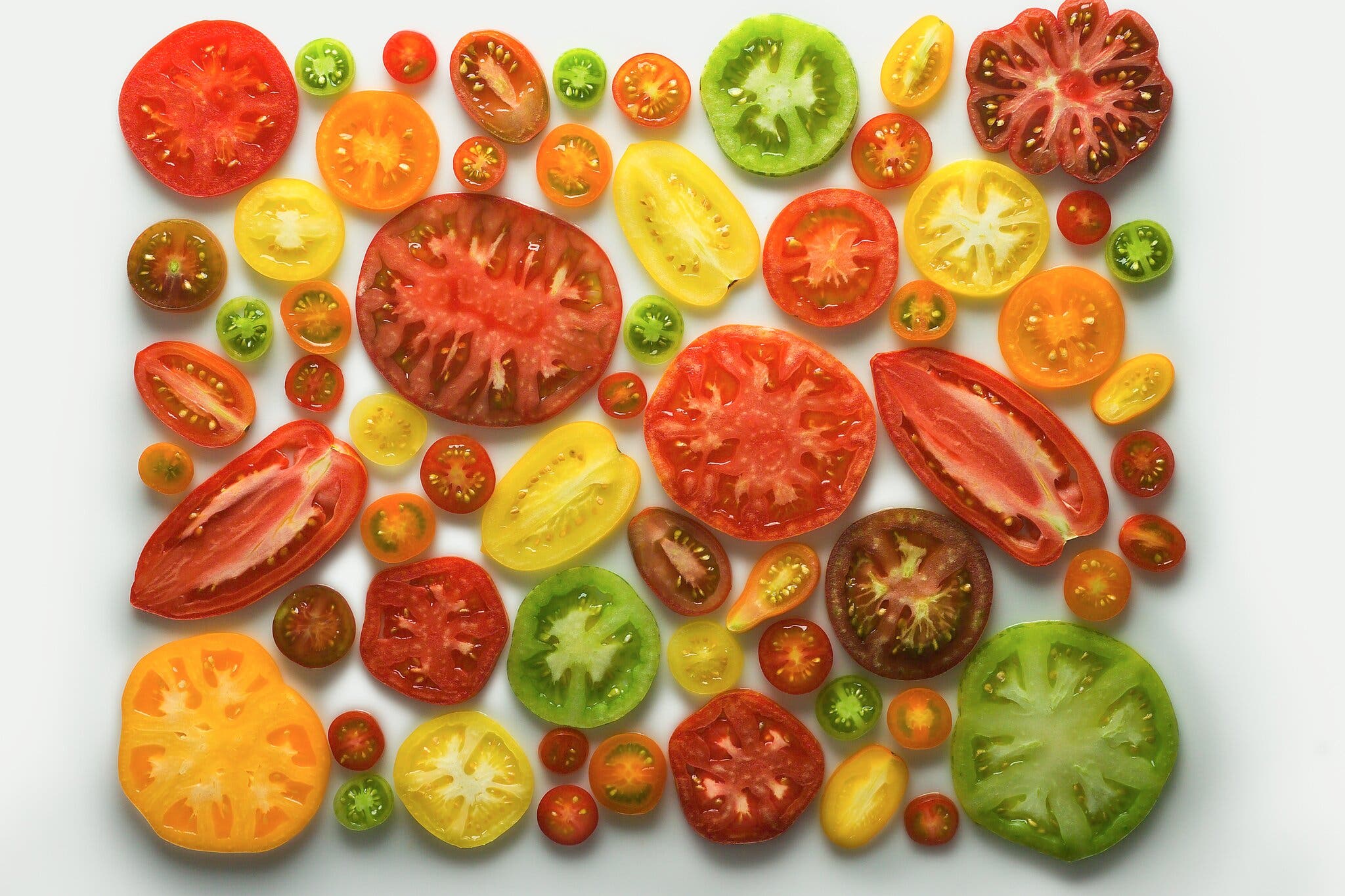 An overhead image of assorted tomato slices.