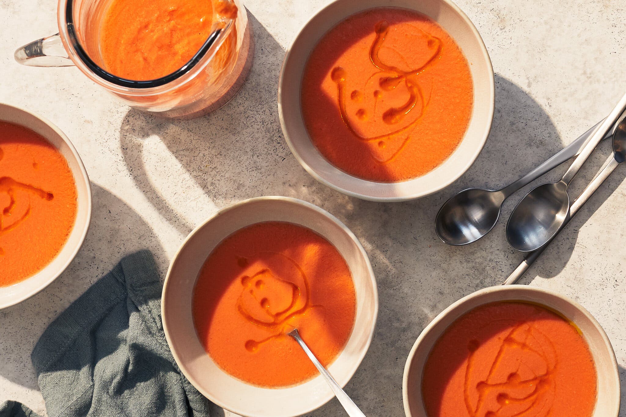 An overhead image of four bowls of a red soup.